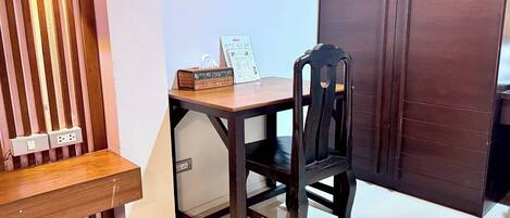 A small wooden desk with a chair, a tissue box, and a menu sign.
