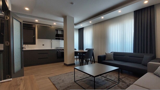 Una sala de estar moderna con un sofá, una mesa de centro y un comedor con mesa y sillas.