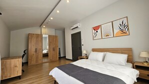 A modern bedroom with a wooden bed, a desk, and a wardrobe.
