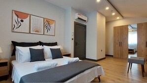 Ein modernes Schlafzimmer mit einem großen Bett, Nachttischen, einem Kleiderschrank und einem Spiegel.