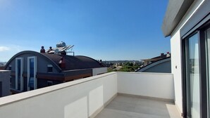 Eine Dachterrasse mit freiem Blick auf die umliegenden Gebäude und den Himmel.