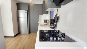 Eine moderne Küche mit einem Edelstahlkühlschrank, einem Gasherd und einer Kaffeemaschine.