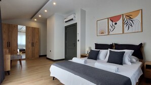 Ein modernes Schlafzimmer mit einem großen Bett, einem Holzschrank und einem Schreibtisch.