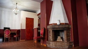 A room with a fireplace, two chairs, a wooden door, and a chandelier. - Imperial Guest House - Full Apartment no kitchen (Roma)