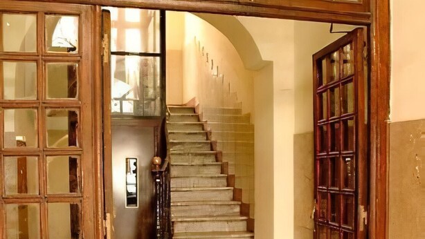 A staircase with a wooden railing and a stone floor, leading to an upper level. - Imperial Guest House - Full Apartment no kitchen (Roma)
