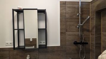 Chuveiro, toalhas de banho, sabonete, papel higiênico