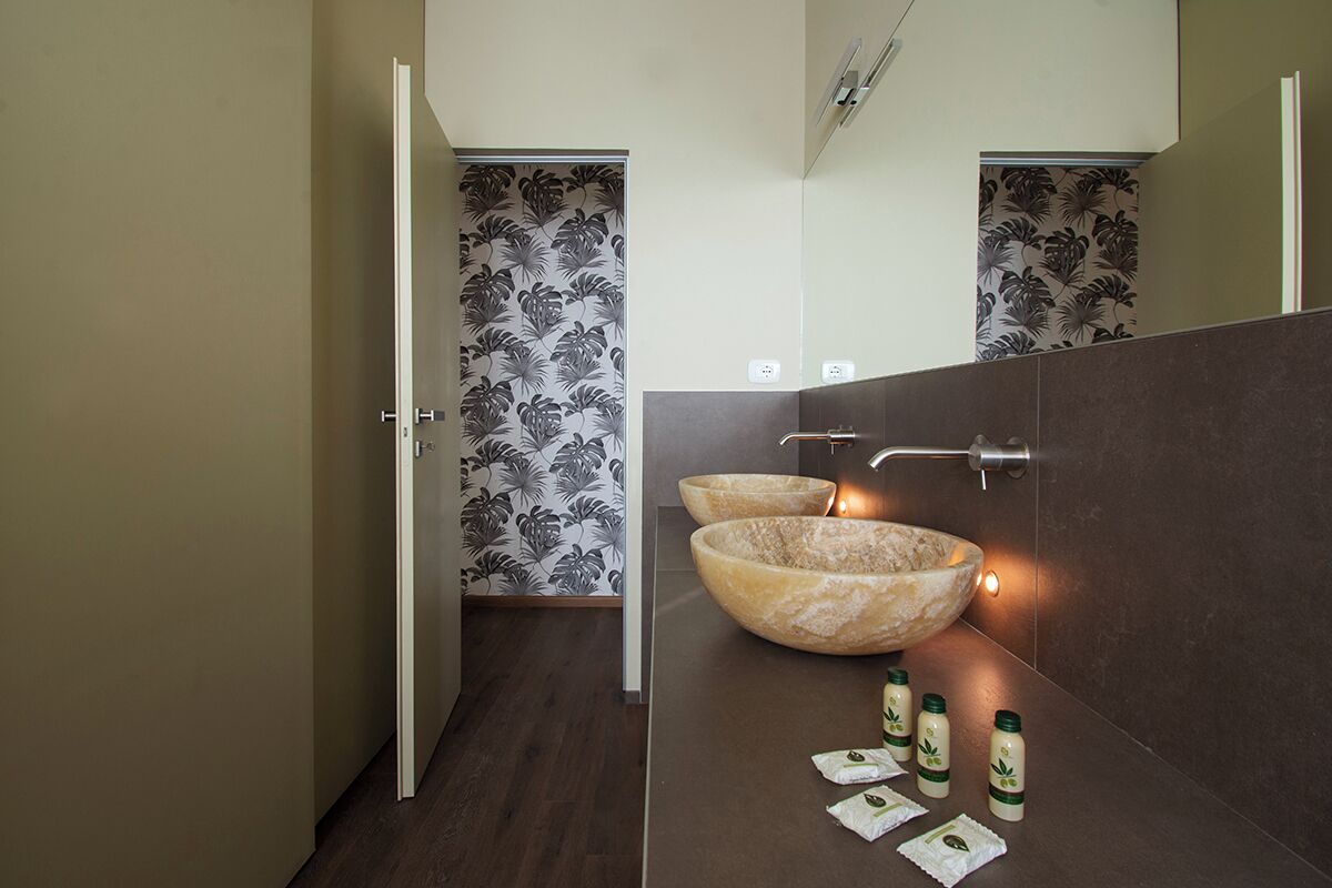 Une salle de bain moderne avec un grand lavabo en pierre et un miroir au-dessus.
