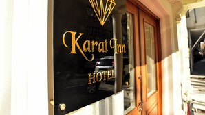 A sign for the Karat Inn Hotel with a diamond-shaped logo. - Karat Inn Boutique Hotel (Baku)
