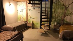 Ein Schlafzimmer mit zwei Betten, einer Holzleiter, einem Nachttisch und einem Wandbild.