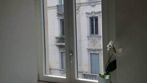 Una habitación con un ventanal que da a un edificio de arquitectura clásica.