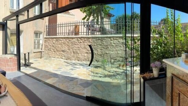 A modern kitchen with a stone backsplash, a built-in oven, and a large island with a sink. - Sofia Konaklama (Istanbul)