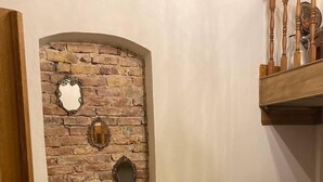 A living room with a brick wall, a brown sofa, a small round table, and a wooden railing. - Sofia Konaklama (Istanbul)