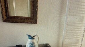 A small room with a checkered wall, a wooden desk, a purple chair, and a mirror above the desk. - Rose de Picardie in BAIE DE SOMME 3 minutes from the beach and shops (Cayeux-sur-Mer)