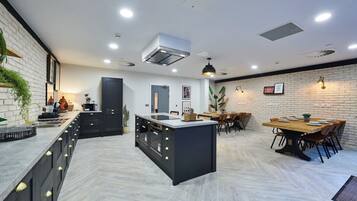 A modern kitchen with a central island, built-in cabinets, and a dining area with a wooden table and chairs.
