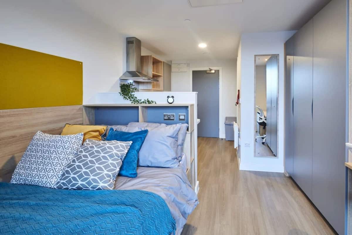 A modern bedroom with a bed, bedside table, and a wardrobe.