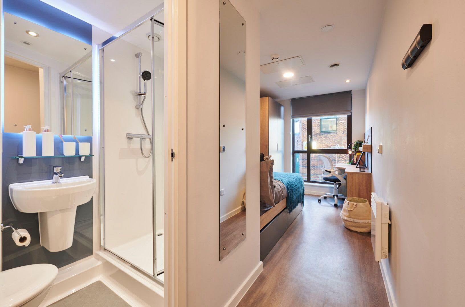 A modern bathroom with a glass shower enclosure, a sink, and a toilet.