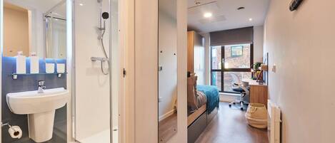 A modern bathroom with a glass shower enclosure, a sink, and a toilet.