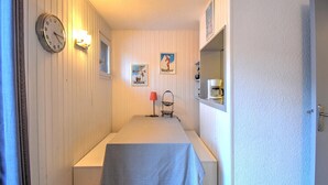 A narrow room with a bed, a clock, and a small table with a lamp. - 3-room apartment with southwest view and wifi in Morzine (Morzine)
