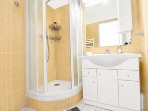 A bathroom with a shower, a sink, and a mirror. - Charming T2 in Sète with private garage (Sète)