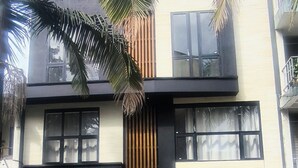 A modern two-story building with large windows, a wooden slatted facade, and a balcony. - zenia (Medellín)