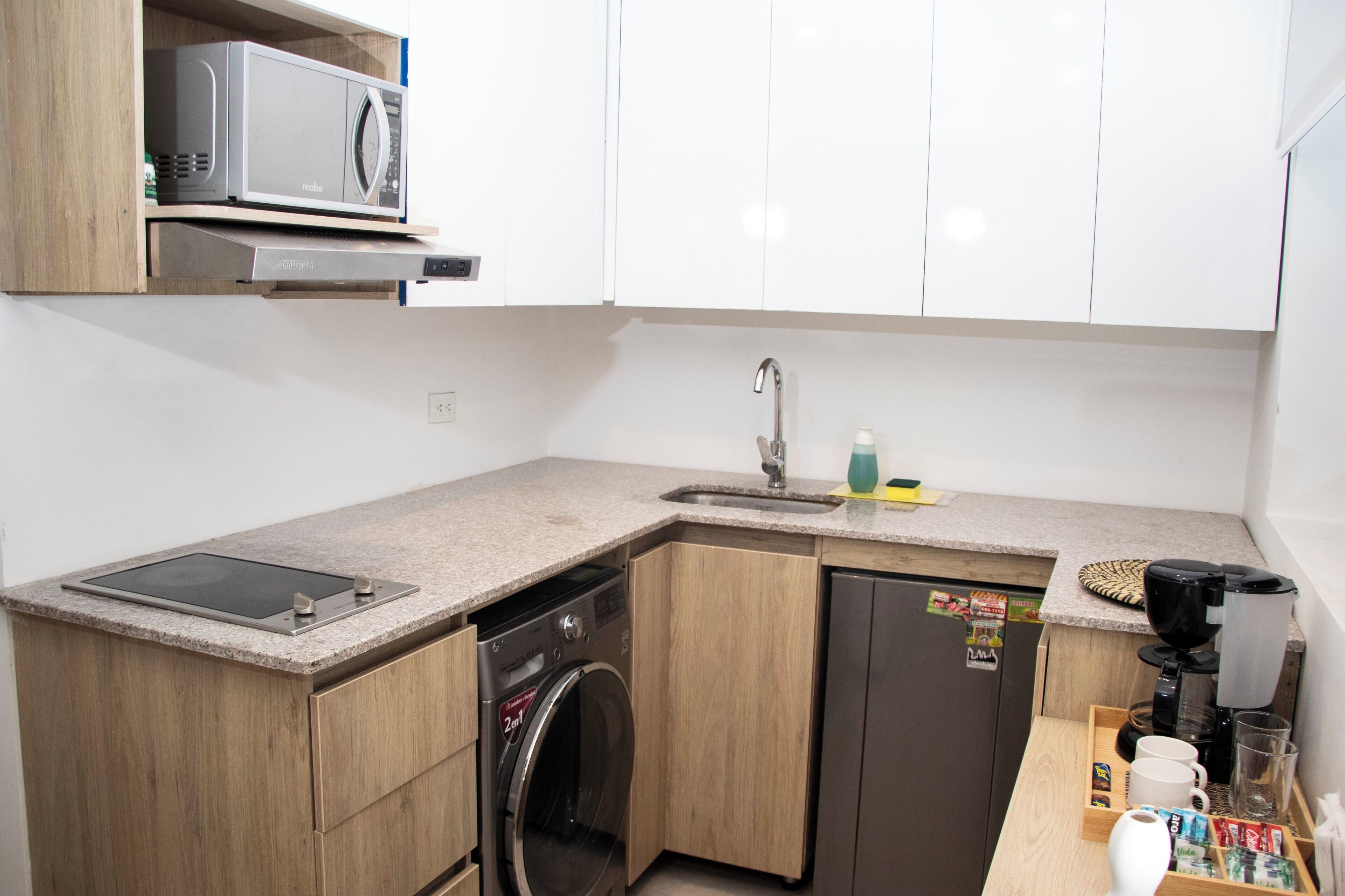 A compact kitchen with a microwave, dishwasher, and coffee maker.
