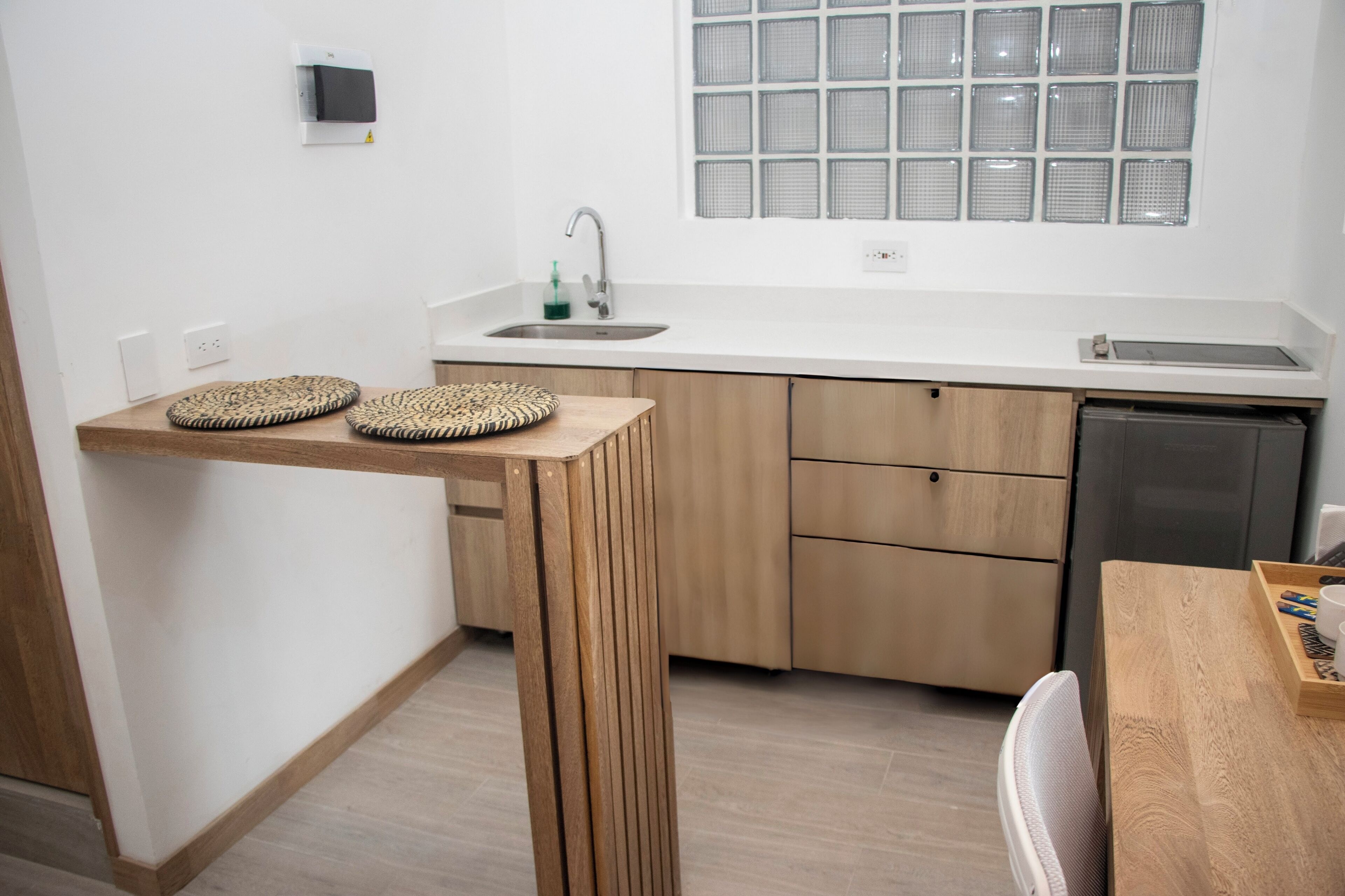 Eine moderne Küche mit Holztisch, integriertem Spülbecken und einem Fenster mit Gittermuster.