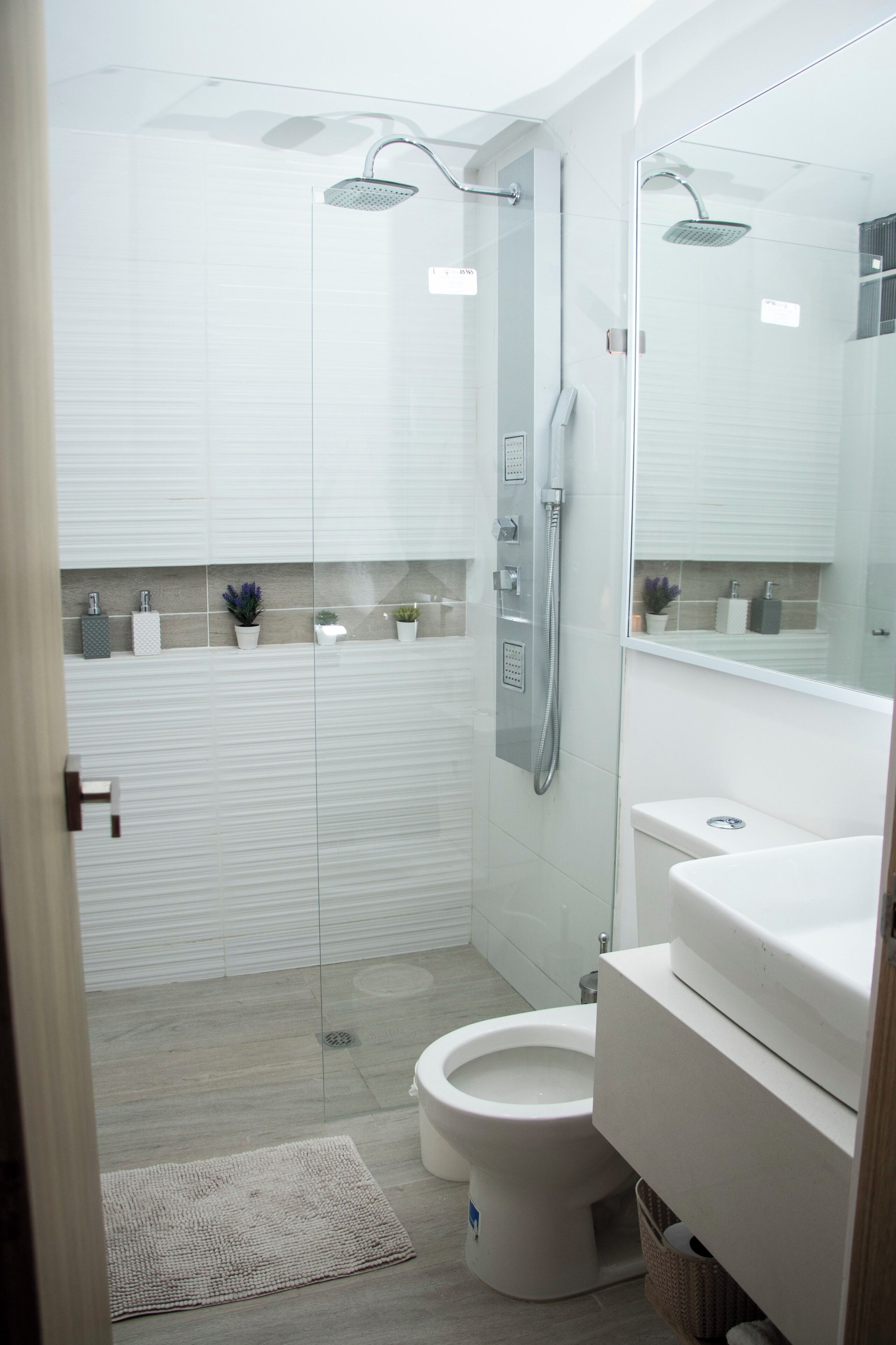 Une salle de bain moderne avec une douche à parois de verre, des toilettes et un lavabo.