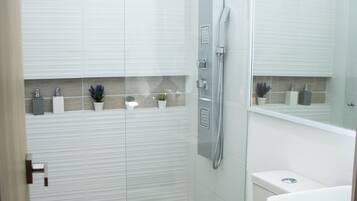 Une salle de bain moderne avec une douche à parois de verre, des toilettes et un lavabo.