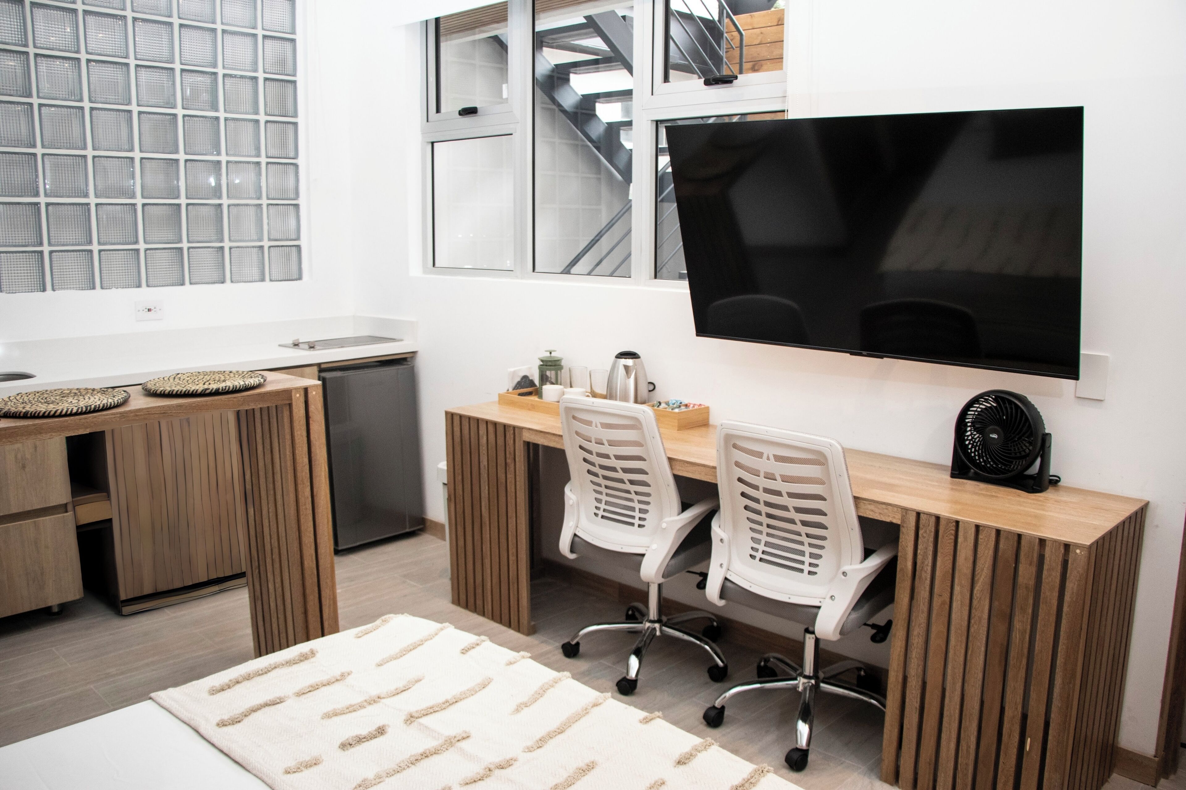 A modern kitchen with a built-in stove, a sink, and a large window with a view of a staircase.