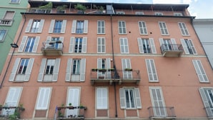 A multi-story building with balconies, white shutters, and a green facade. - VivimiHome-Duomo Cioffi House (Milan)