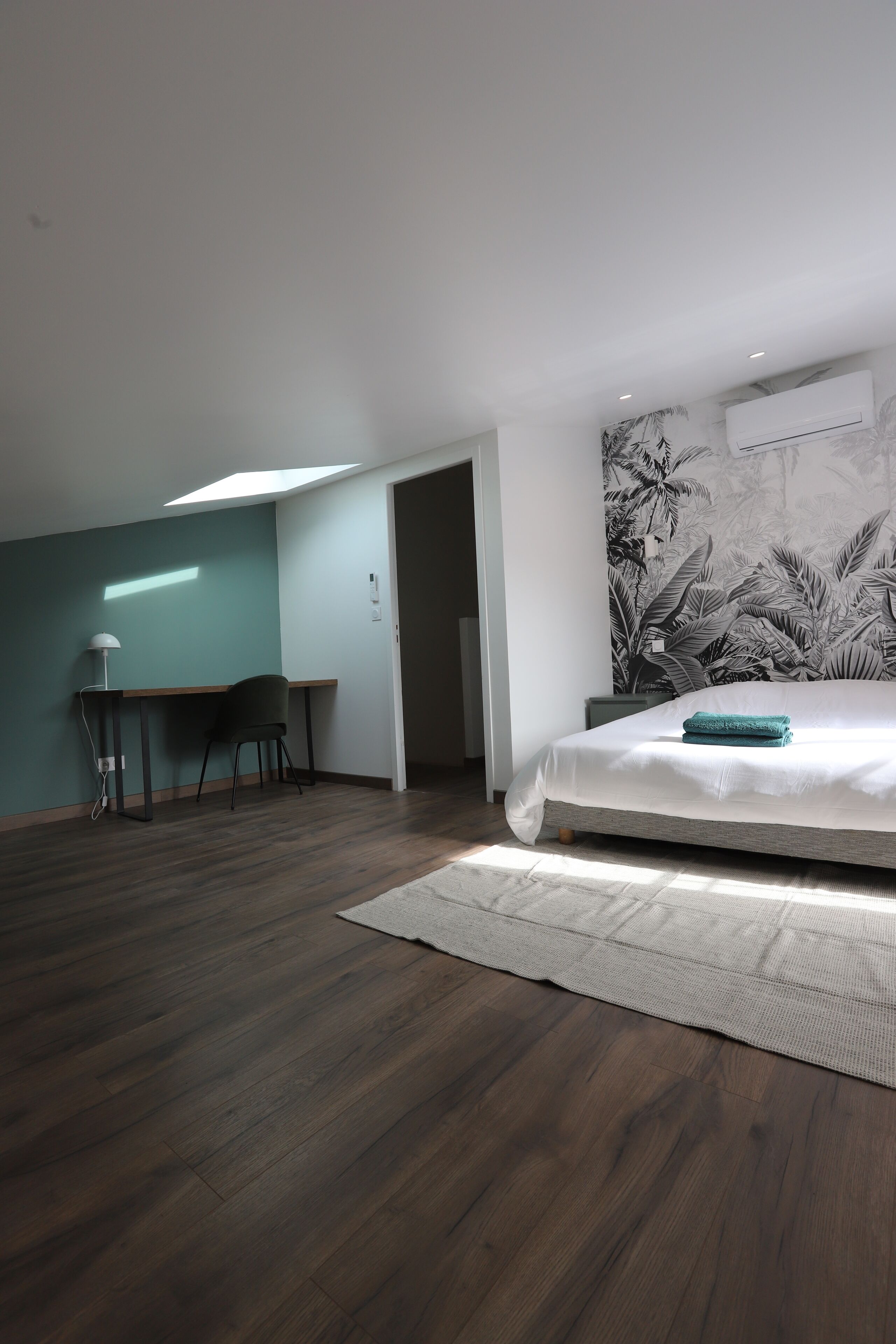 A bedroom with a bed, a desk, and a chair.