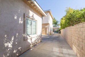 Stylish building with a flat roof and natural design elements, featuring a window with a green shutter.