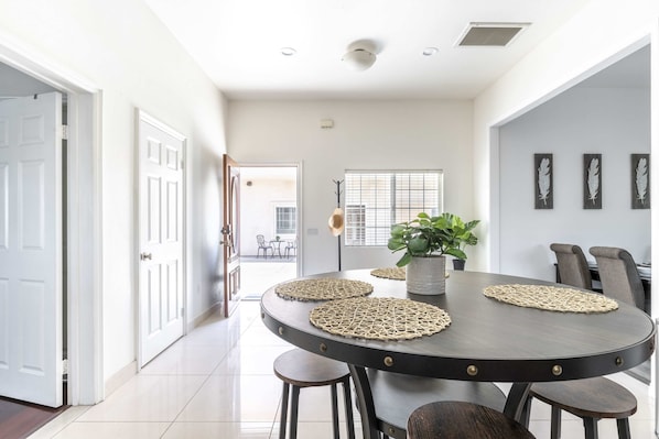 Enjoy meals in this stylish dining area with a round table for four, woven placemats, and matching chairs.