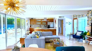 Un salon moderne comprenant un canapé, une table basse et un coin repas avec une table et des chaises.