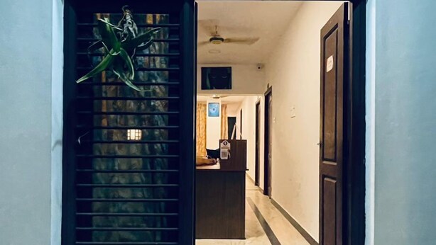 A doorway leading into a hallway with a red carpet and a ceiling fan. - VCP Beach Resort (Puducherry)