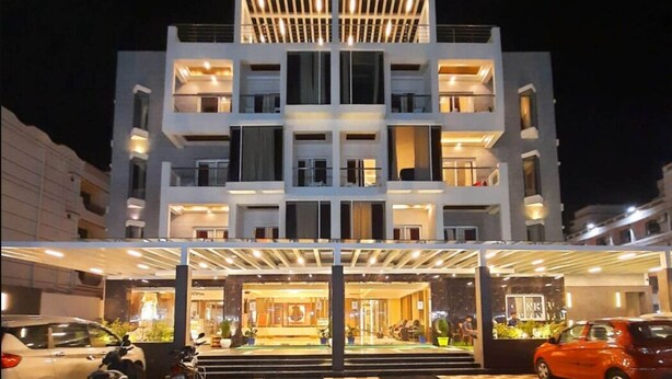 Un hotel moderno a più piani, con balconi, ampie finestre e un ingresso luminoso.