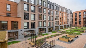 A modern building with multiple floors, large windows, and a courtyard with seating areas and greenery. - Student Only Zinc Quarter (Bristol)