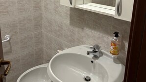 Un baño con inodoro, bidé y lavamanos.