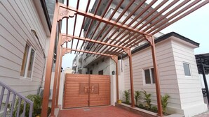 A gated entrance with a wooden gate and a pergola structure. - Brij Hari Villa (Varanasi)