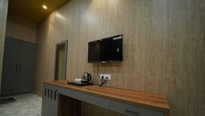 A modern kitchen with a wooden countertop, a built-in oven, and a flat-screen TV mounted on the wall. - Brij Hari Villa (Varanasi)