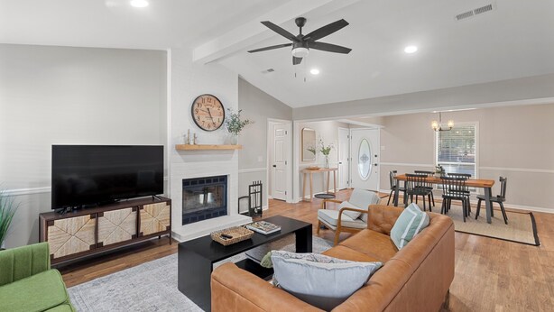 A modern living room with a flat-screen TV, leather sofa, and a fireplace. - Renovated 3 Bed 2 Bath,Dog Friendly, Game Room, Fenced Yard, Well Equipped Kitchen, 5 Smart TVs (Dothan)