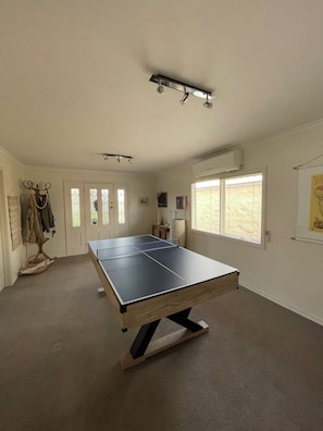 Enjoy a game of ping pong in this room's central recreational area, featuring a carpeted floor and climate control.