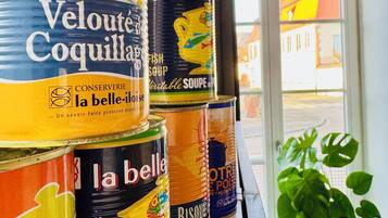 A shelf with various canned goods, including 'Velouté Coquillards' and 'la belle' soup cans.