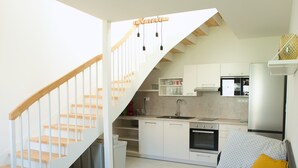 Eine moderne Küche mit wei ßen Schränken, einem eingebauten Backofen und einer Mikrowelle.