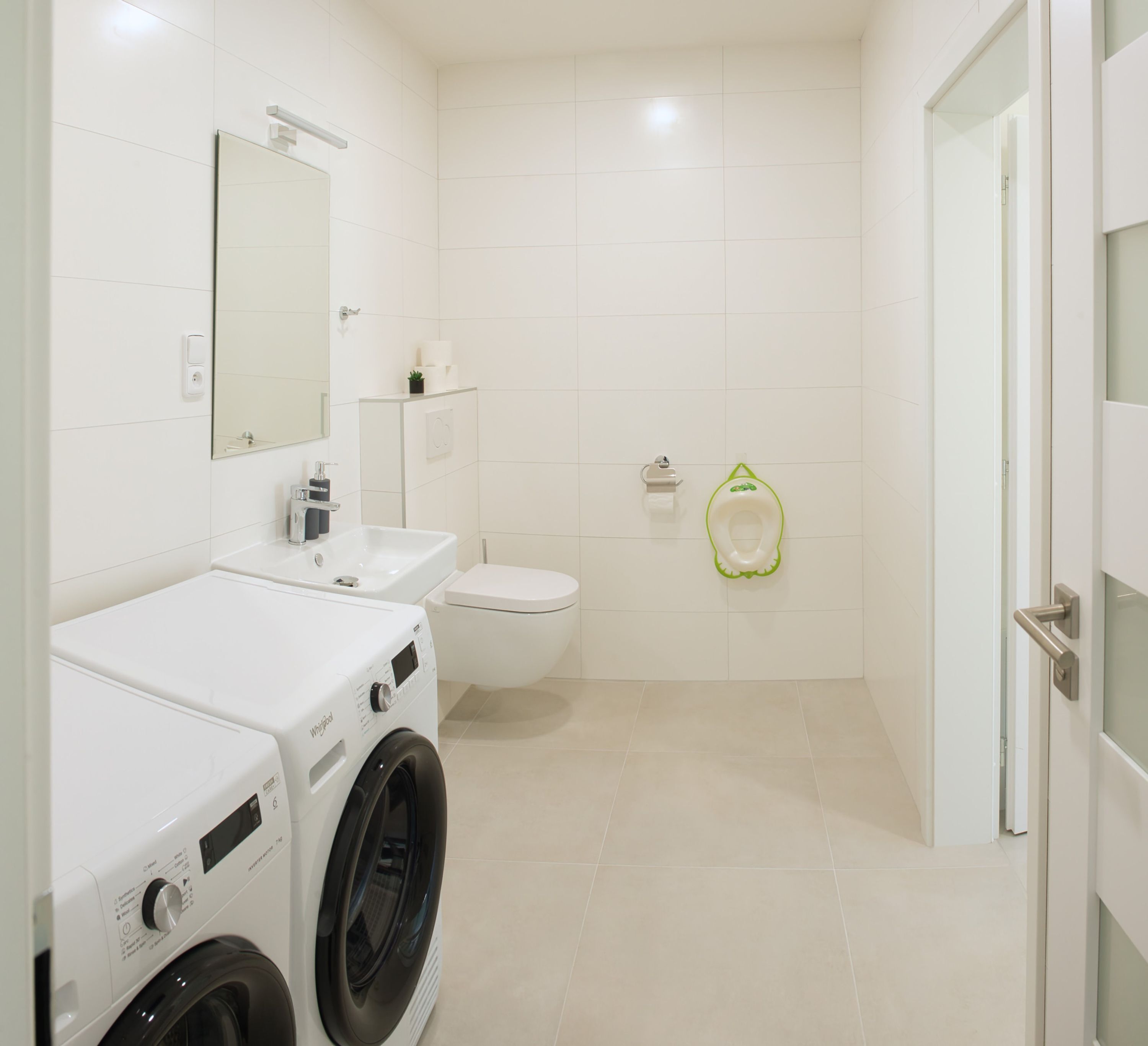 Un bagno moderno con lavandino, water e vasino per bambini verdi.