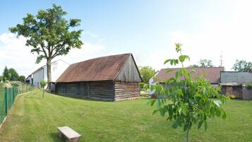 Experience a tranquil countryside retreat in this traditional barn, surrounded by lush trees and a serene lawn.