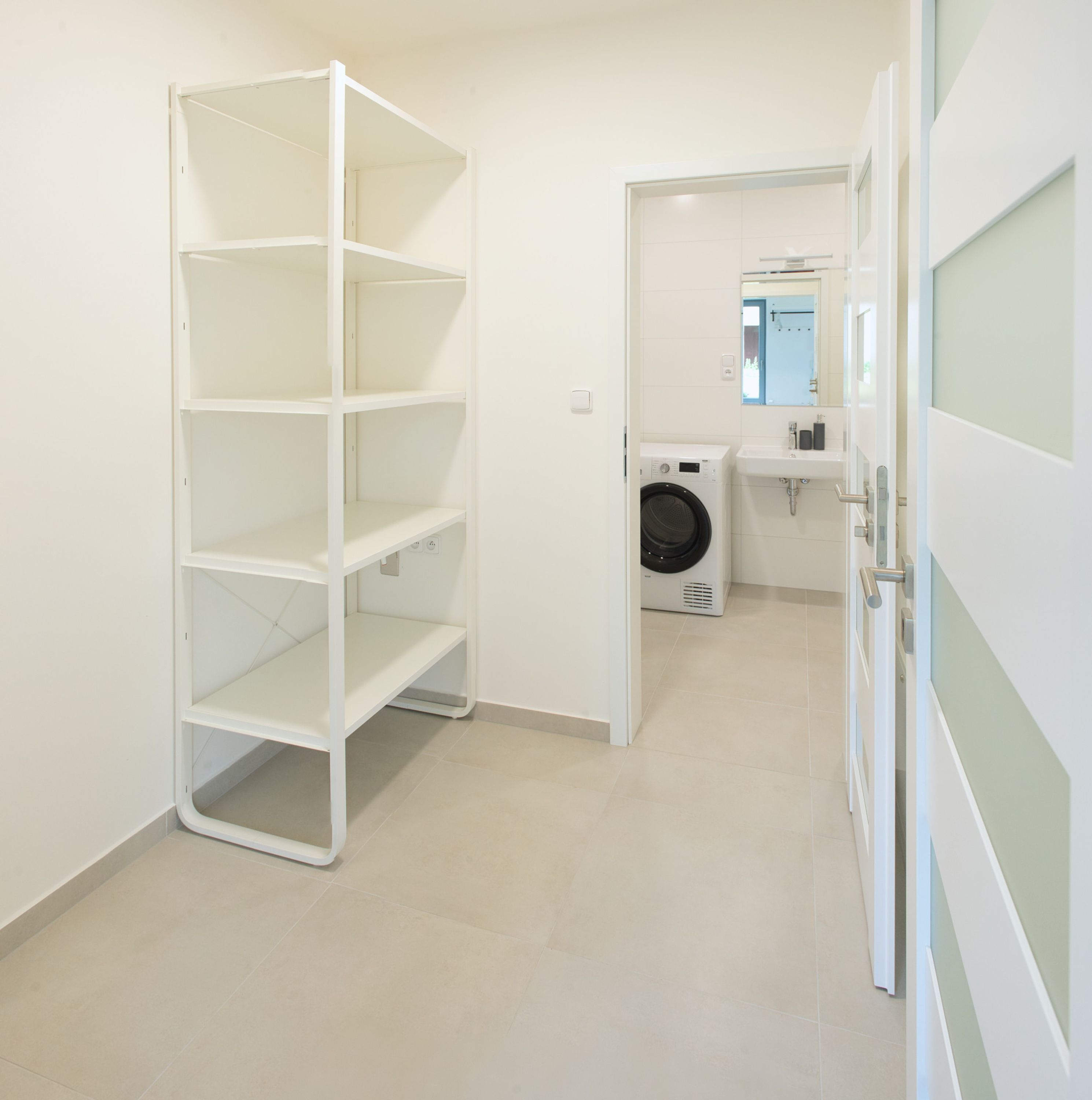 A laundry room with a washing machine and a sink.