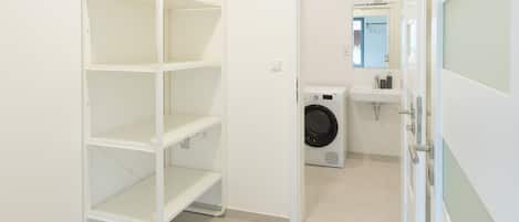 A laundry room with a washing machine and a sink.
