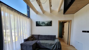 Una sala de estar moderna con un sofá, una mesa de centro redonda y un cuadro en la pared.
