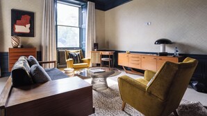 A modern living room with a sofa, armchairs, a coffee table, and a wooden cabinet. - 3 Johns Place Townhouse (Edinburgh)